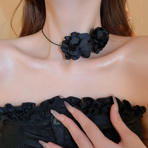 Gros plan d'un élégant collier ras du cou avec fleur en tissu noir en 3D