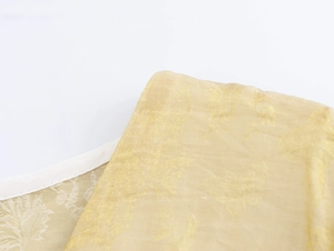 Détail macro du tissu jaune transparent avec motif papillon jacquard et passepoil blanc
