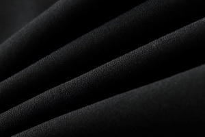 Vue macro de la texture du tissu tissé noir avec des détails de plis élégants