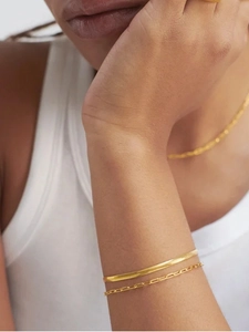 Detailed view of gold snake chain and minimalist linking bracelet set on a wrist