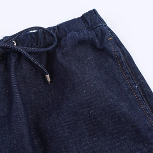 Gros plan détaillé de la taille en denim bleu foncé avec bande élastique et cordon à embout
