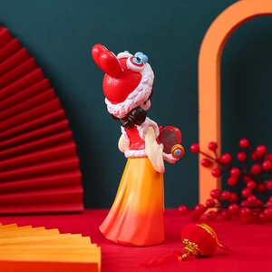 Detailed close-up of a festive girl figurine with a lion dance hat and red hanfu outfit