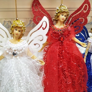 Close-up of lace angel ornaments with glitter wings and colorful fabric skirts