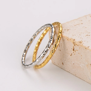 Sparkling hammered texture rings in gold and silver finish on stone base