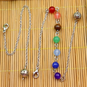 Detailed shot of seven chakra stone beads with silver hollow metal balls on chain