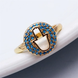 Nahaufnahme des goldenen Hamsa-Rings mit blauen Perlen und offenem Hand-Design