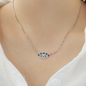 Close-up of S925 sterling silver evil eye necklace with blue cubic zirconia on a model
