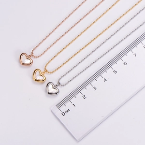 Gros plan de pendentifs cœur en nacre en trois couleurs avec règle pour la taille
