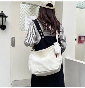 Close-up of white canvas tote bag with a cute white bear plush keychain on the side