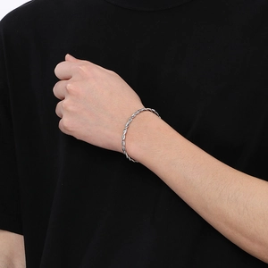 Detail shot of a silver twisted cable cuff bracelet in stainless steel on a model wrist