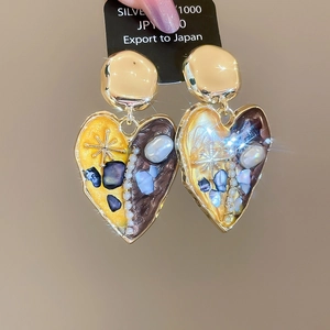 Detail of vintage heart earrings with gold metal, mixed resin, and irregular pearls