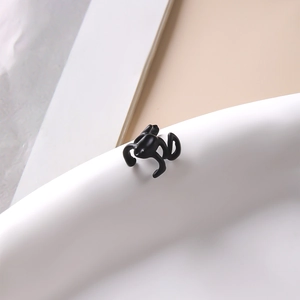 Vue macro d'un ear cuff noir évidé en métal au design punk moderne et style gothique