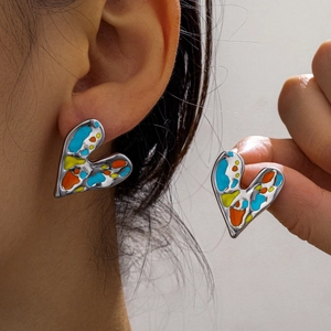Detailed close-up of heart-shaped stainless steel earrings with colorful enamel paint