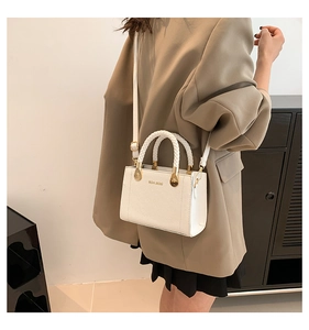 Détails du sac blanc grainé avec poignées tressées et finitions métalliques dorées