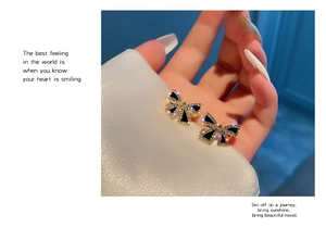 Close-up of elegant s925 silver black bow earrings with crystal pavé and 18k gold plating
