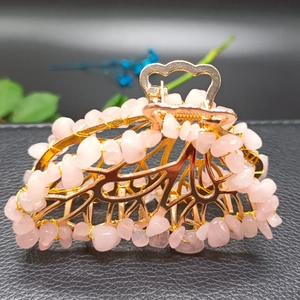 Detail showing pink crystal stones hand-wired on a golden alloy butterfly hair clip