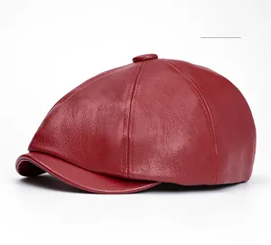 Close-up of deep red PU leather newsboy hat showing fine texture and panel stitching