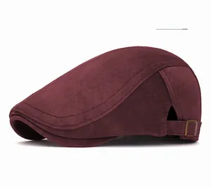 Detail of burgundy newsboy cap with suede texture and adjustable side metal buckle
