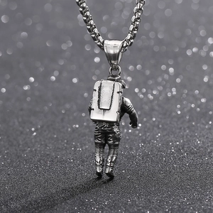Silver steel astronaut pendant necklace with matte finish on a starry black background