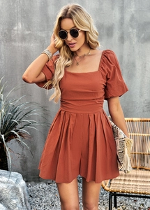 Detail of terracotta square neck playsuit with puff sleeves and pleated shorts
