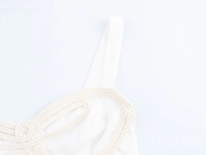 Gros plan d'un haut blanc à bretelles avec des nœuds en corde tressée beige et tissu léger