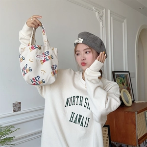 Close-up of beige corduroy tote bag featuring colorful Keep Smiling text and smiley face
