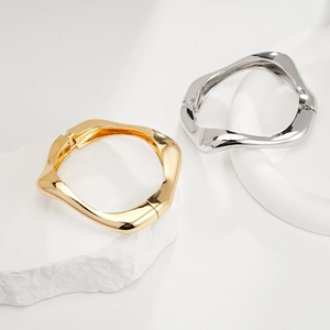 Detail showing irregular twisted metal bangles in gold and silver with hinge mechanism