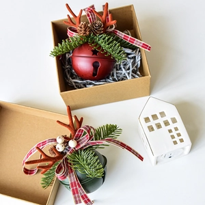 Christmas metal bell ornaments with velvet antlers and pine cones in a kraft gift box