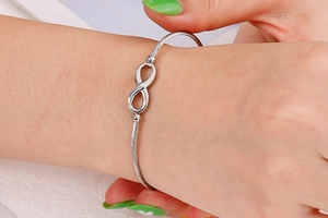 Zilveren infinity armband met spiraalvormige staaldraadtextuur om de vrouwenpols