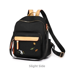 Detail of bunny embroidery and khaki leather trim on black waterproof nylon backpack