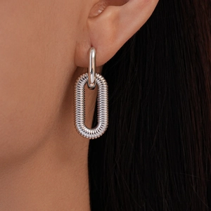 Close-up of silver-toned double-hoop earrings featuring a spiral textured texture design