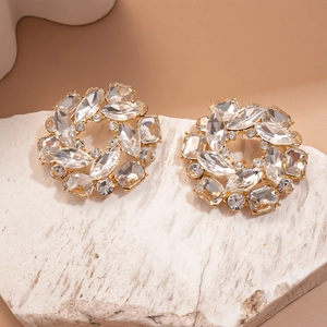 Gros plan de boucles d'oreilles fleurs dorées avec cristaux sur pierre