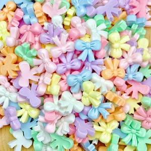 Macro shot of colorful mini resin bow charms in various candy colors for nail art and jewelry