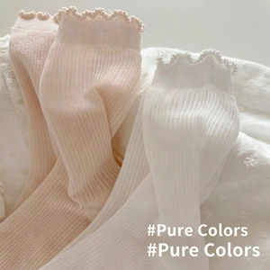 White and beige hollow-out cotton crew socks with frilly lace edges and ribbed texture