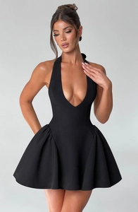 Detail view of the deep V-neckline and halter neck design on a black A-line pleated dress