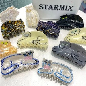 Detailed view of various cat-shaped hair claw clips in colorful acetate and patterns
