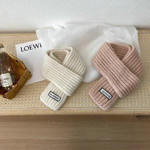 Detailed texture of rib-knitted scarves in beige and dusty pink with KN STUDIO woven labels