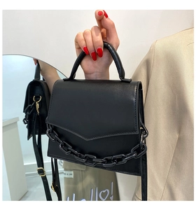 Detail of black PU leather square bag with thick resin chain and V-shaped flap