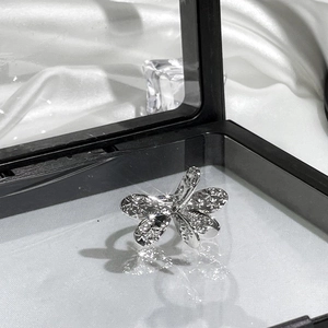 Detailed macro view of a silver dragonfly ring with sparkling crystals in a jewelry box