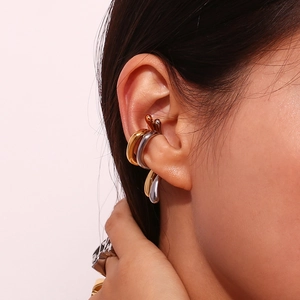 Detail of gold and silver liquid metal ear cuffs styled together on a model's ear