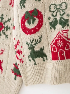 Détail de la maille beige épaisse avec des motifs de Noël rouges et verts festifs