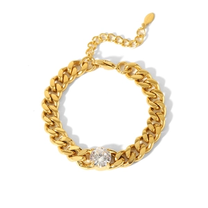 Macro view of gold plated Cuban link bracelet with a large central sparkling zircon