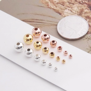 Detailed comparison of S925 silver round beads in gold and silver beside a 10-cent coin