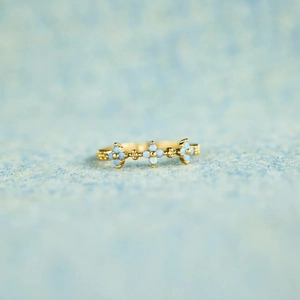 Elegant gold S925 sterling silver ring with three light blue gemstones on blue background