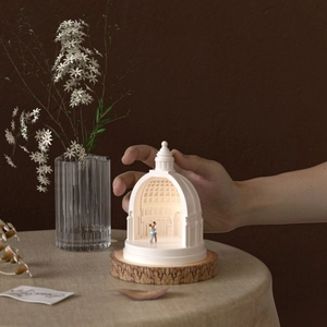 Detail view of miniature couple inside a white dome resin architecture on a wood base