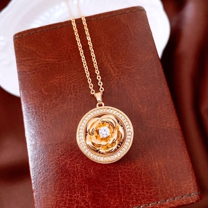 Close-up of golden vintage rotating flower pendant with sparkling zircon and fine O-chain