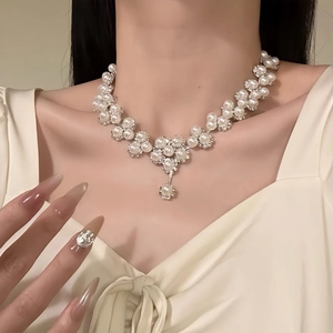 Detail of elegant pearl and rhinestone flower necklace with silver metal drop pendant