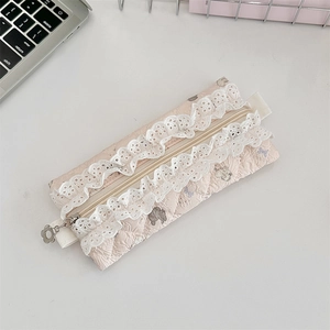 Close-up of pink quilted pencil case featuring lace embroidery and flower zipper pull