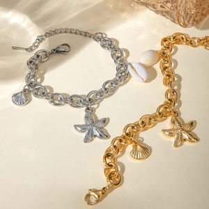 Gold and silver ocean charm bracelets featuring starfish and natural seashell pendants