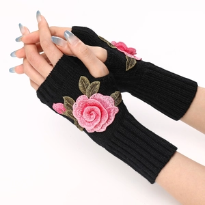 Close-up of black knitted fingerless gloves with detailed pink rose floral embroidery